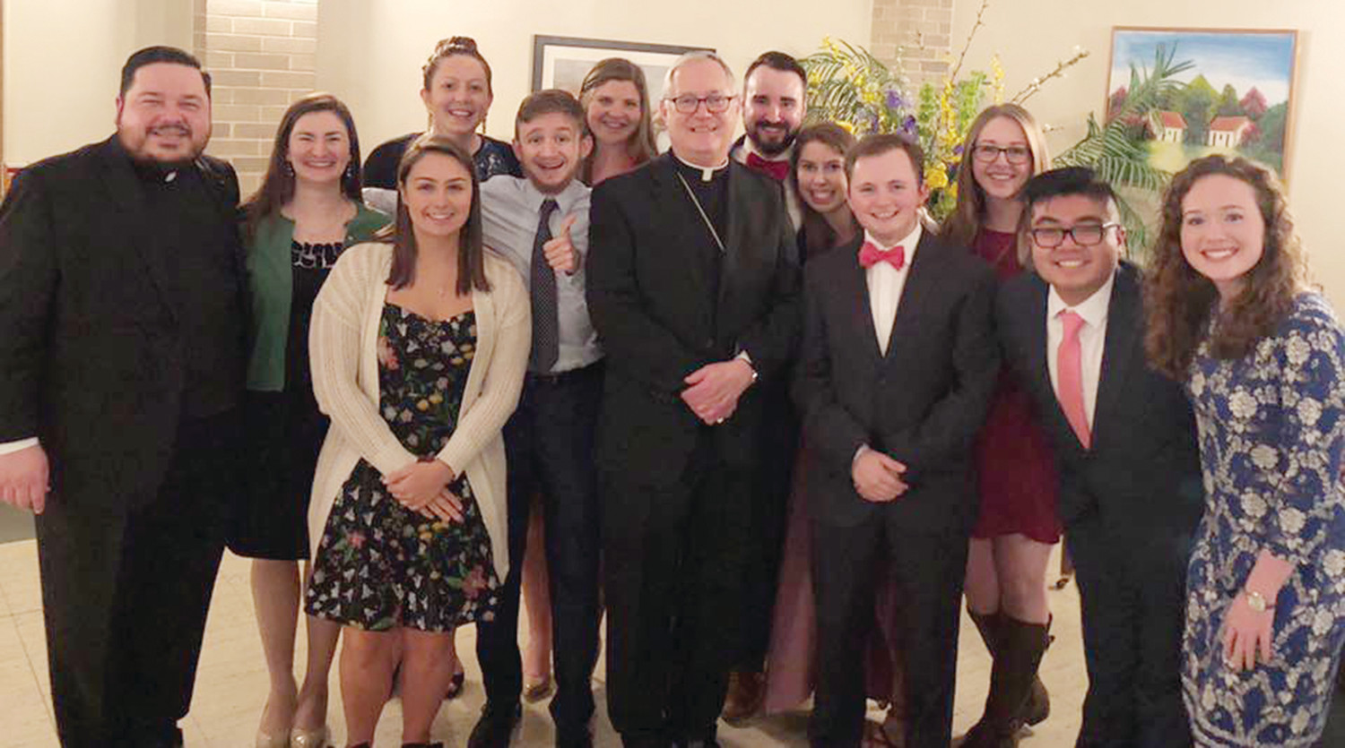 Bishop Tobin is pictured with the staff and student executive board of the Catholic Center, along with current URI chaplain Father Joseph Upton, at left.